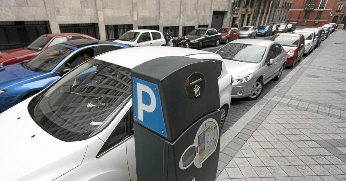 horarios y tarifas zona azul valladolid calle con coches aparcados en la zona azul de Valladolid, en primer plano un parquímetro