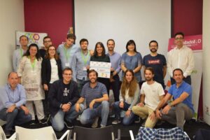 grupo de personas posando para una foto y en medio mujer sostiene un diploma