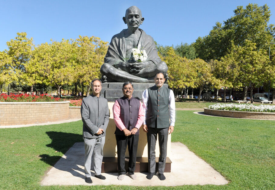 tres personas adultas hombre delante de estatua de Ghandi